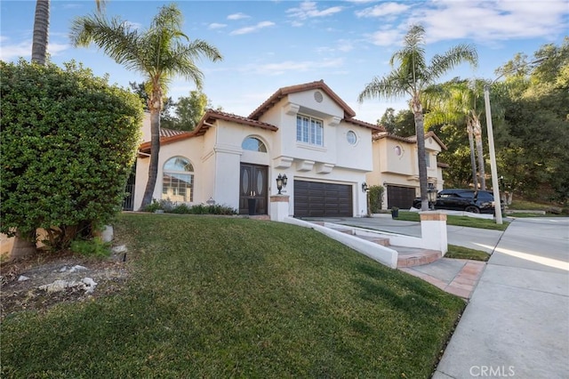 mediterranean / spanish home featuring a garage and a front lawn