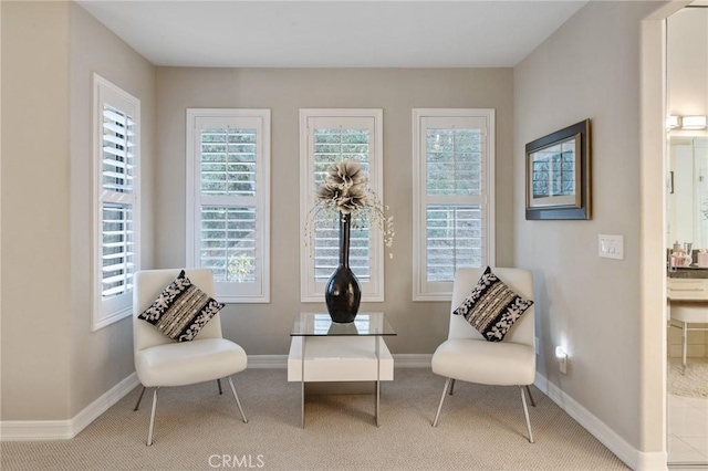 sitting room featuring a wealth of natural light and light colored carpet