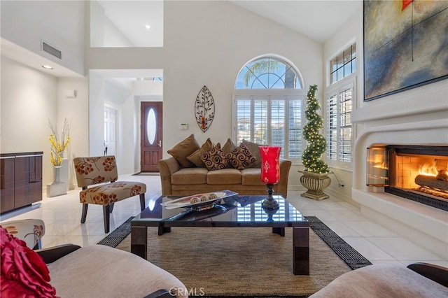 living room with light tile patterned floors and high vaulted ceiling