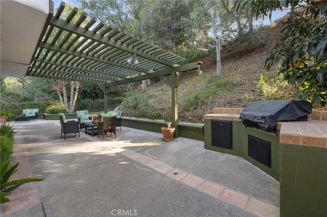 view of patio with area for grilling, a grill, and a pergola