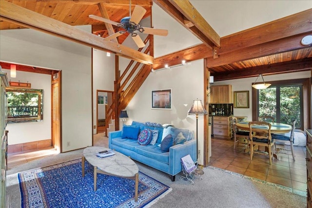 carpeted living room with beamed ceiling, ceiling fan, and high vaulted ceiling