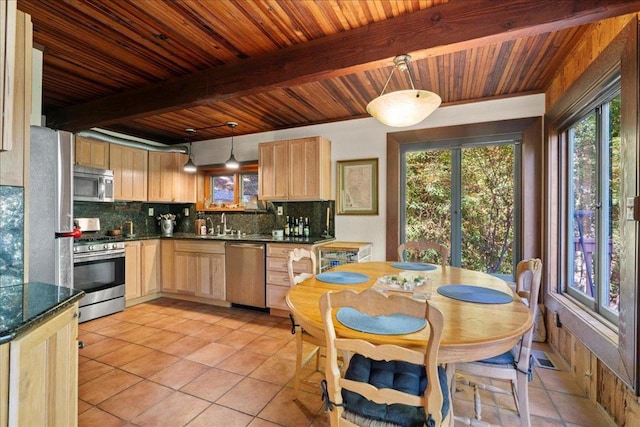 kitchen featuring stainless steel appliances, tasteful backsplash, pendant lighting, and light brown cabinets