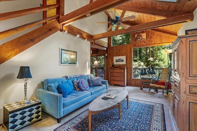 carpeted living room featuring high vaulted ceiling, wood walls, beamed ceiling, ceiling fan, and wood ceiling