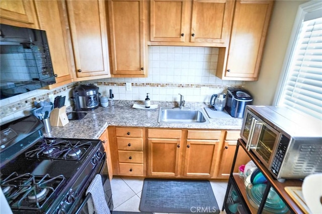 kitchen with light tile patterned flooring, sink, black appliances, plenty of natural light, and backsplash