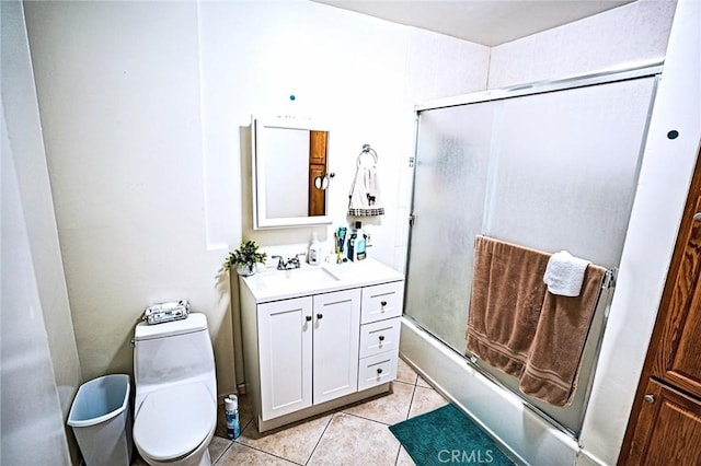 full bathroom featuring bath / shower combo with glass door, tile patterned floors, vanity, and toilet