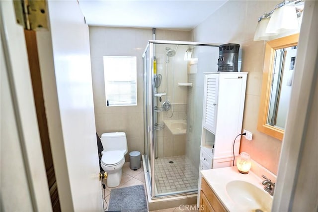 bathroom featuring tile patterned flooring, vanity, a shower with shower door, and toilet