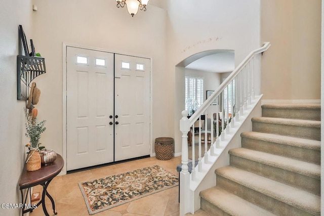 tiled foyer entrance with a high ceiling