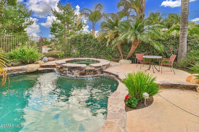 view of swimming pool featuring an in ground hot tub and a patio