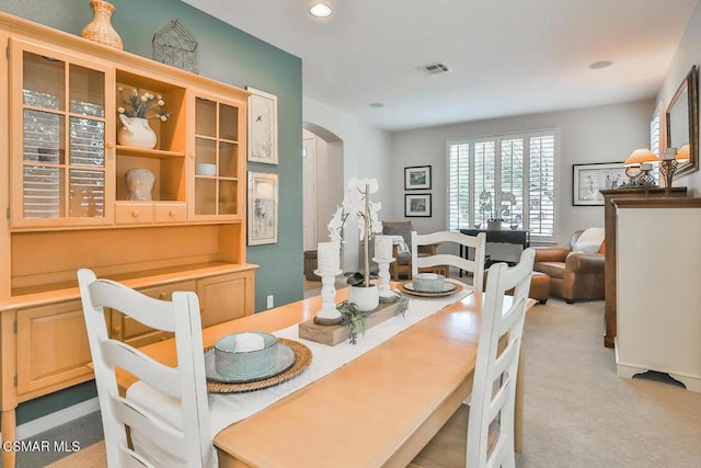 dining space featuring light carpet