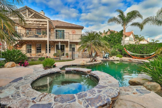 view of swimming pool with an in ground hot tub