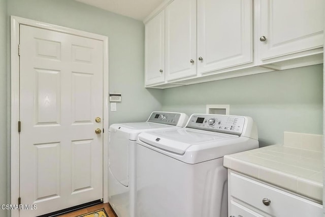 laundry room featuring cabinets and washing machine and clothes dryer