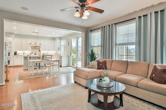 living room featuring ceiling fan and light hardwood / wood-style floors