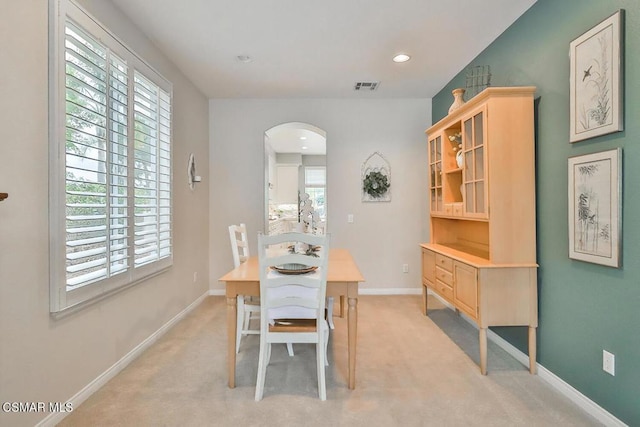 dining space with plenty of natural light and light carpet