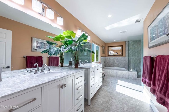 bathroom with vanity and shower with separate bathtub