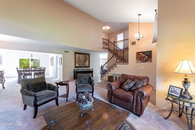 living room with an inviting chandelier, a high ceiling, and carpet