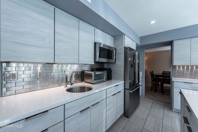 kitchen featuring sink, high end refrigerator, and backsplash