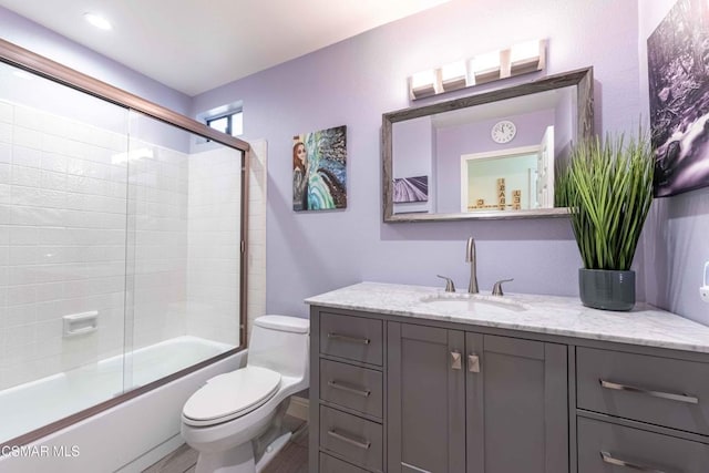 full bathroom with shower / bath combination with glass door, vanity, and toilet