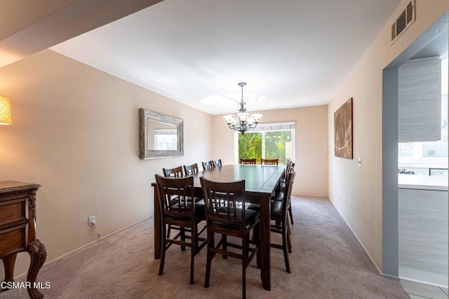 dining space featuring a chandelier and carpet flooring