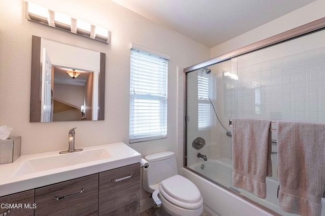 full bathroom featuring bath / shower combo with glass door, vanity, and toilet