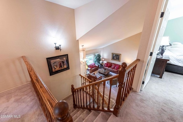 stairs featuring vaulted ceiling and carpet flooring