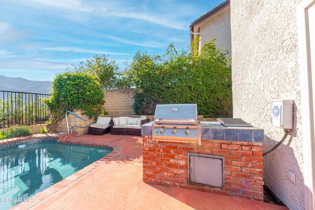 view of swimming pool with area for grilling, grilling area, a mountain view, and a patio area