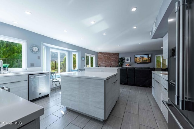 kitchen featuring a spacious island, appliances with stainless steel finishes, sink, and a wealth of natural light