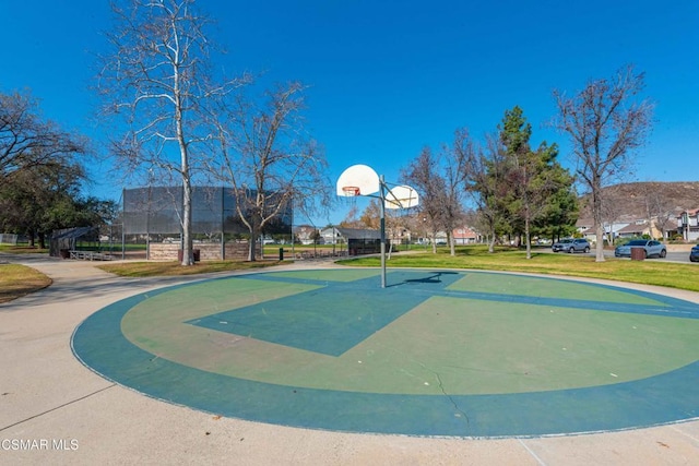 view of sport court featuring a lawn