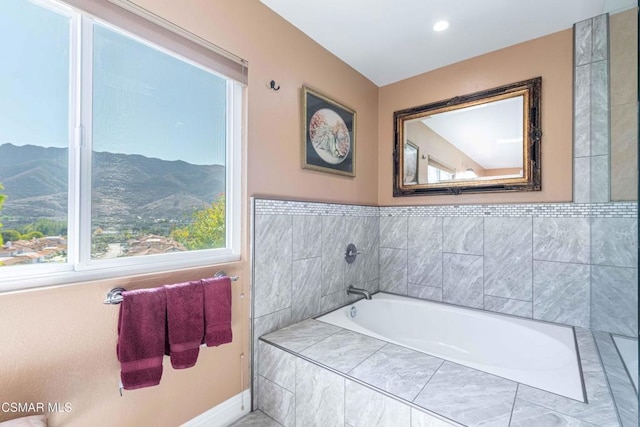 bathroom with a mountain view and a relaxing tiled tub