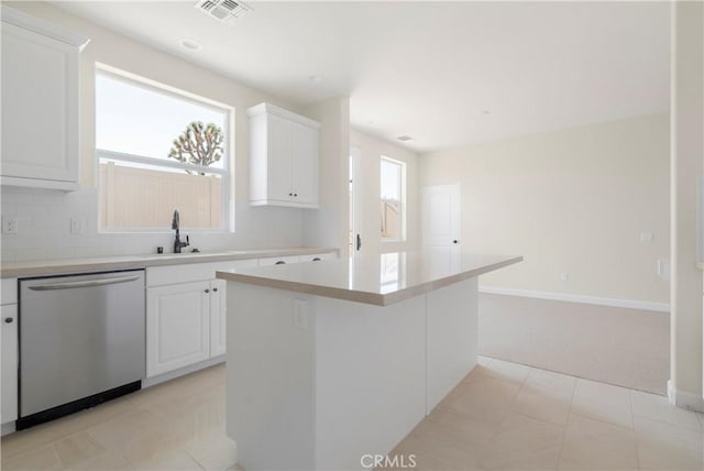 kitchen with a kitchen island, stainless steel dishwasher, and white cabinets