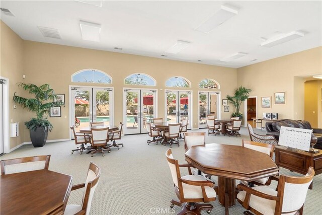 dining room featuring french doors and light carpet