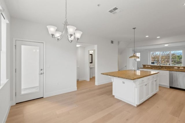 kitchen featuring sink, a center island, dishwasher, pendant lighting, and white cabinets