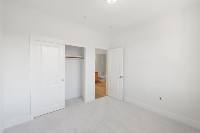 unfurnished bedroom featuring a closet and light carpet