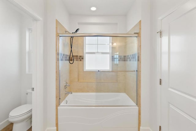 bathroom featuring combined bath / shower with glass door and toilet