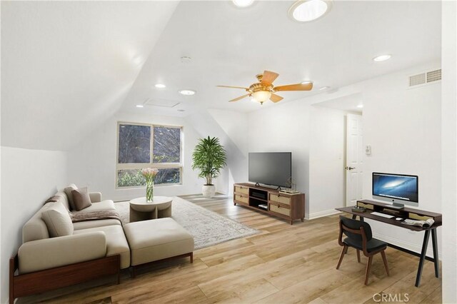 living room featuring vaulted ceiling, ceiling fan, and light wood-type flooring