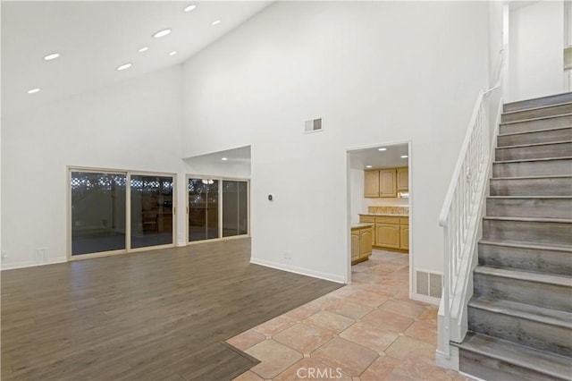 unfurnished living room with stairs, recessed lighting, visible vents, and light wood-style floors