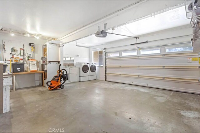 garage with a garage door opener and independent washer and dryer