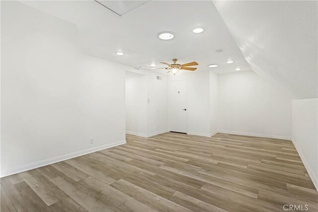 interior space featuring ceiling fan, lofted ceiling, and light wood-type flooring