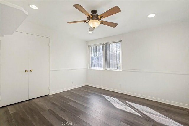 unfurnished bedroom with a closet, recessed lighting, dark wood finished floors, and baseboards