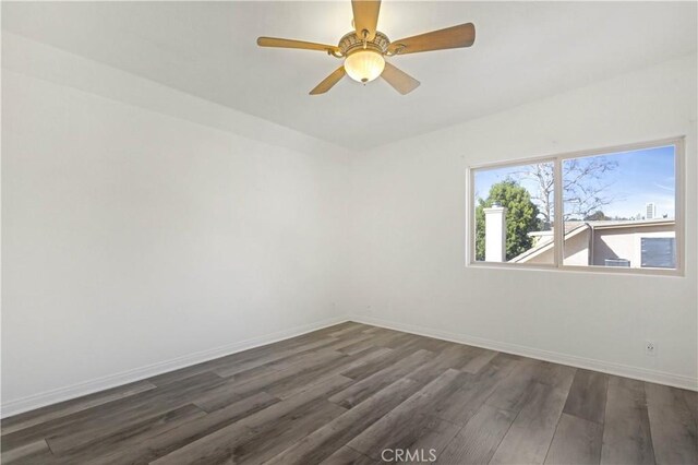 spare room featuring dark hardwood / wood-style flooring and ceiling fan