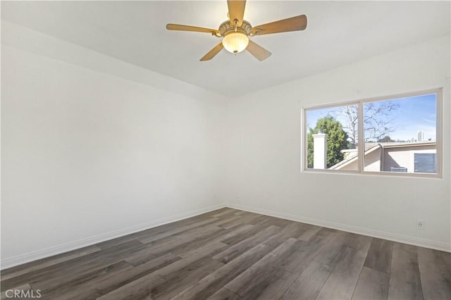 spare room featuring dark wood-type flooring, baseboards, and a ceiling fan