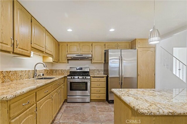 kitchen featuring light stone counters, appliances with stainless steel finishes, sink, and hanging light fixtures