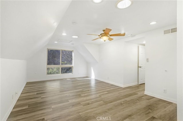 bonus room with lofted ceiling, ceiling fan, wood finished floors, visible vents, and baseboards