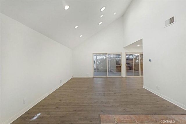 unfurnished living room with recessed lighting, visible vents, dark wood-type flooring, high vaulted ceiling, and baseboards