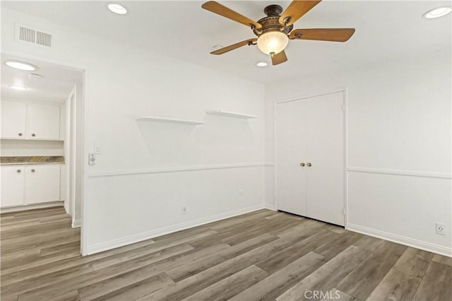 empty room featuring light wood-style floors, recessed lighting, visible vents, and baseboards