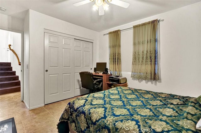 bedroom featuring ceiling fan, a closet, and light tile patterned floors