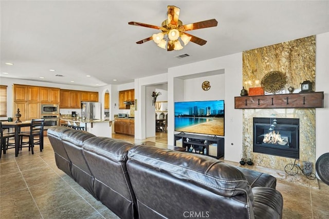 living room featuring ceiling fan and a premium fireplace