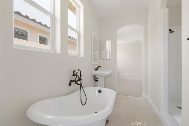 bathroom with separate shower and tub and tile patterned flooring