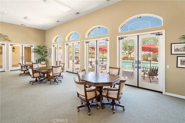 carpeted dining space featuring french doors