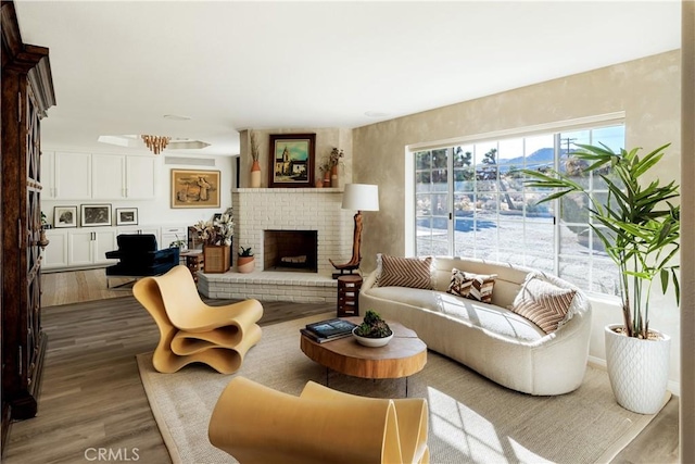 living room with hardwood / wood-style floors and a brick fireplace