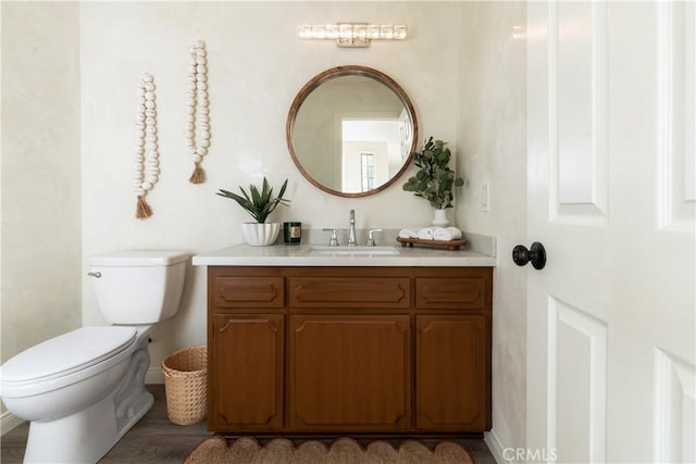 bathroom featuring vanity, hardwood / wood-style floors, and toilet